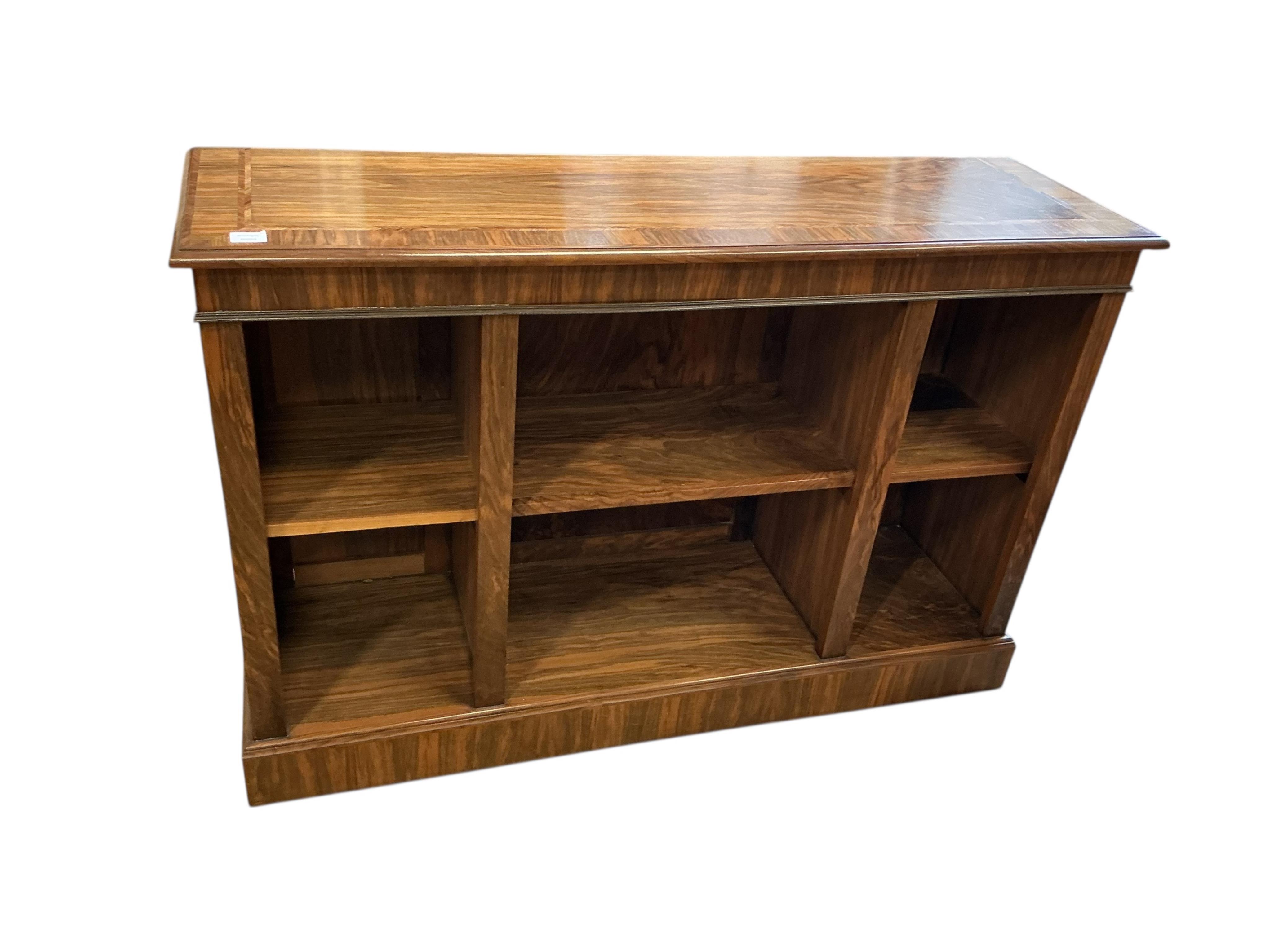 A Regency style feather banded walnut dwarf open bookcase, width 140cm, depth 42cm, height 94cm